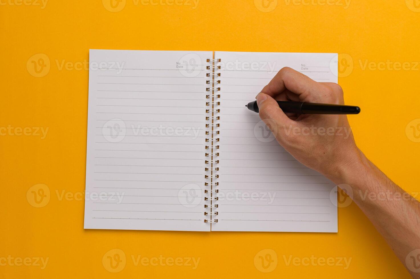 Hand writing in a notebook on yellow background photo