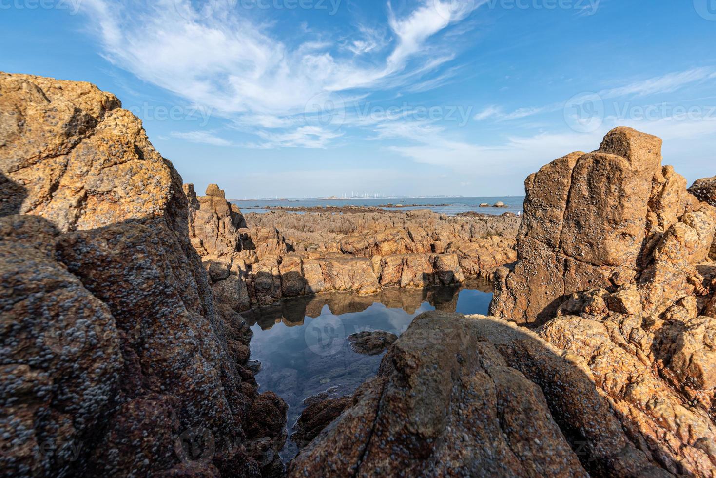 The sea water between the seaside reefs reflects the Yellow reefs and the blue sky photo