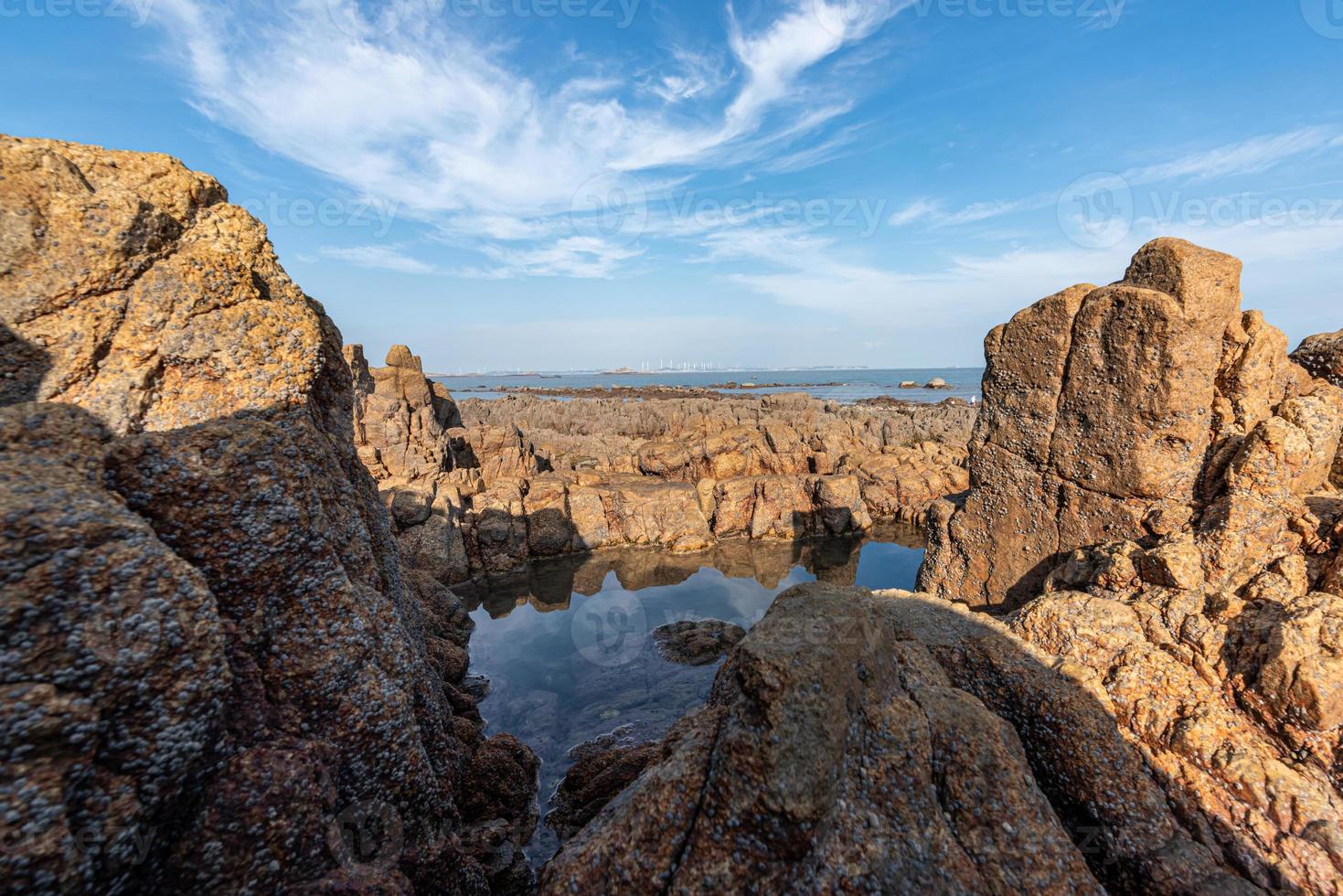 The sea water between the seaside reefs reflects the Yellow reefs and the blue sky photo