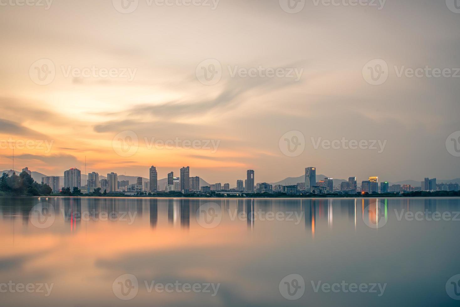 At dusk, the lake reflects the night view of the city photo