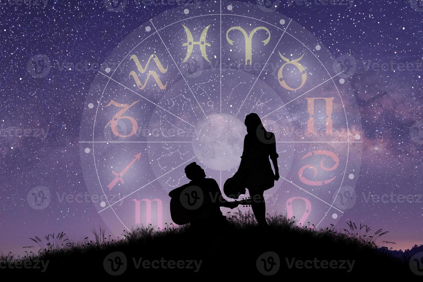 Astrological zodiac signs inside of horoscope circle. Couple singing and dancing over the zodiac wheel. photo