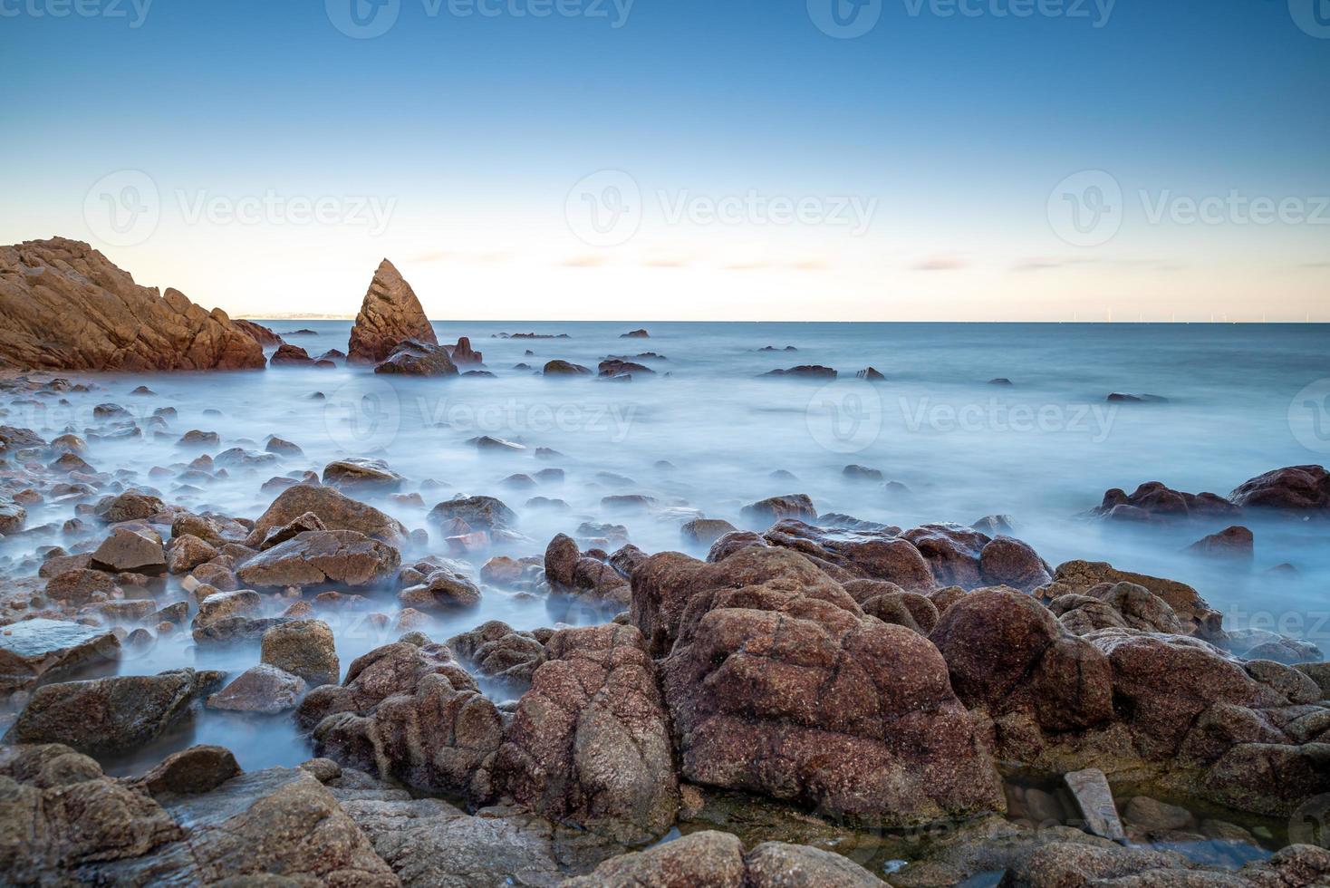 Sea water and reefs by the sea under the blue sky photo