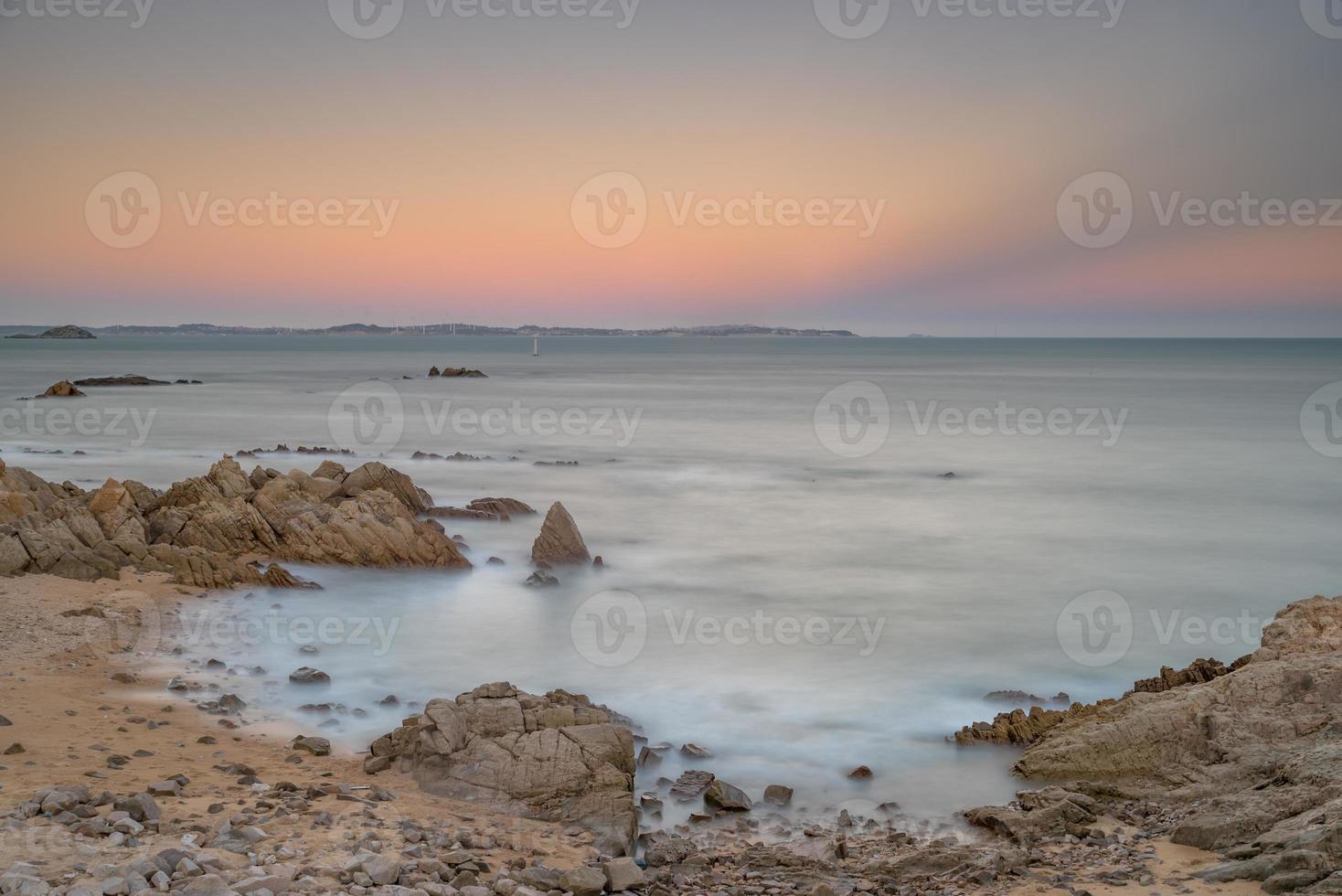 Sea water and reefs by the sea under the blue sky photo
