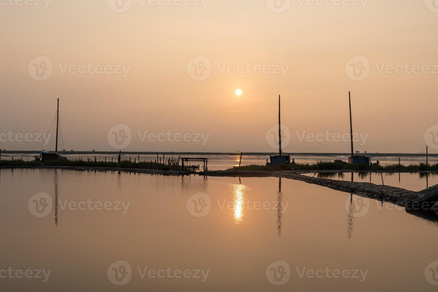 At sunrise in the morning, the sea water reflects the fishing boat photo