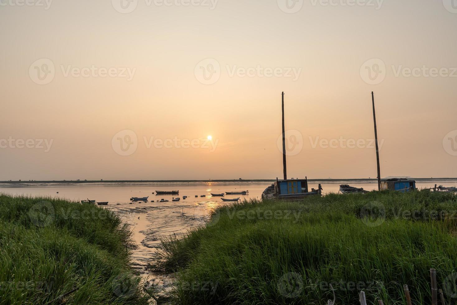 al amanecer por la mañana, el agua del mar refleja el barco de pesca foto