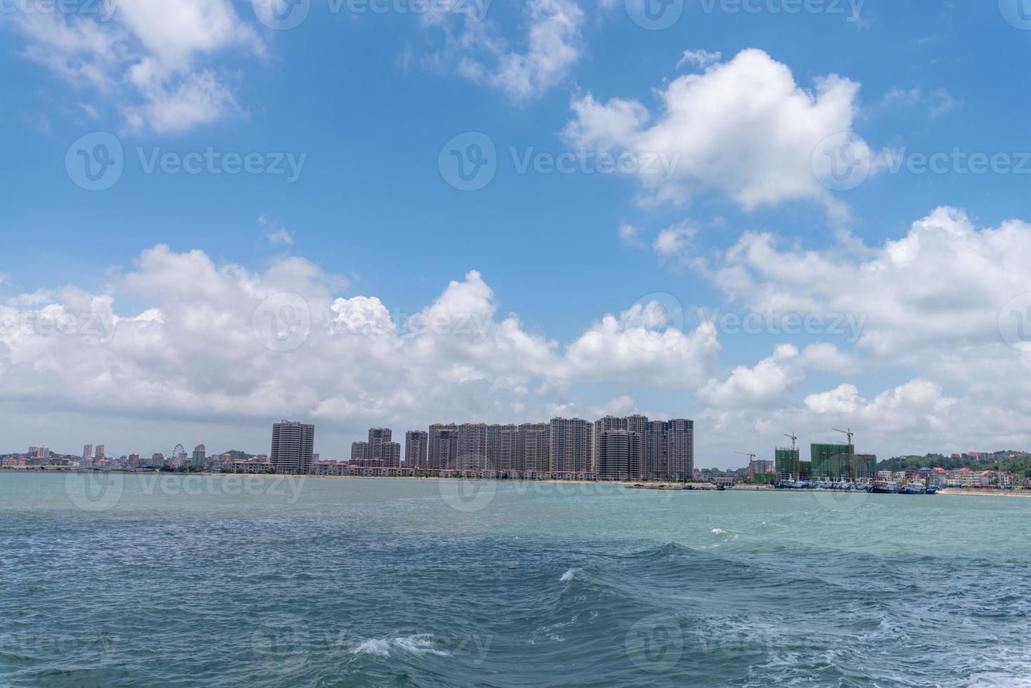 The sea and coastline under blue sky and white clouds photo