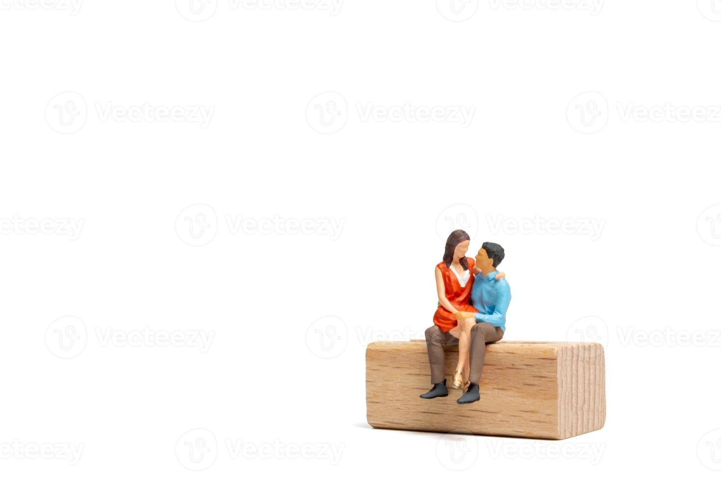 Pareja de personas en miniatura sentada en una silla de madera y espacio para tex foto