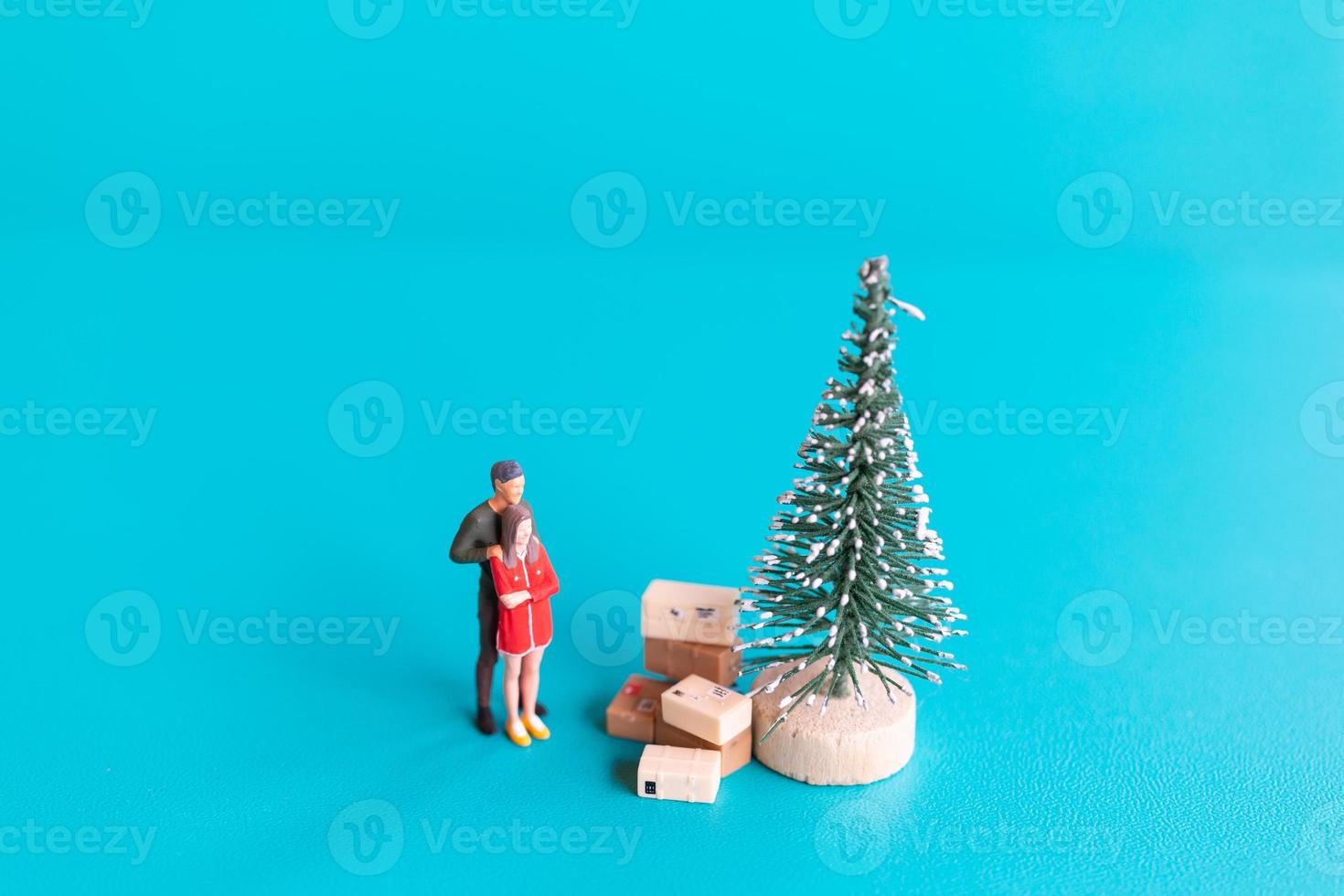 Miniature people, Couple in love standing next to a Christmas tree photo
