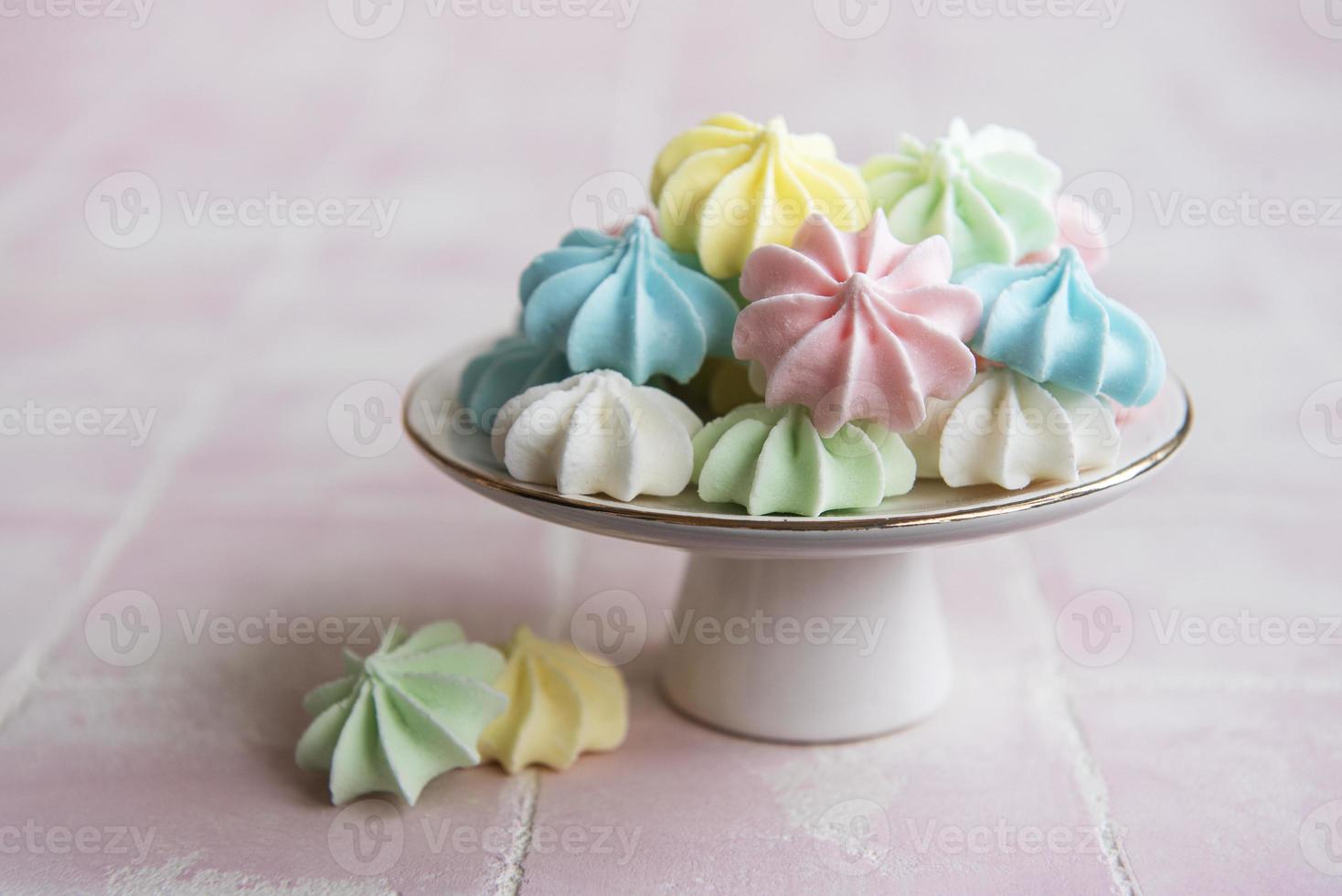 Small colorful meringues on the ceramic  stand photo
