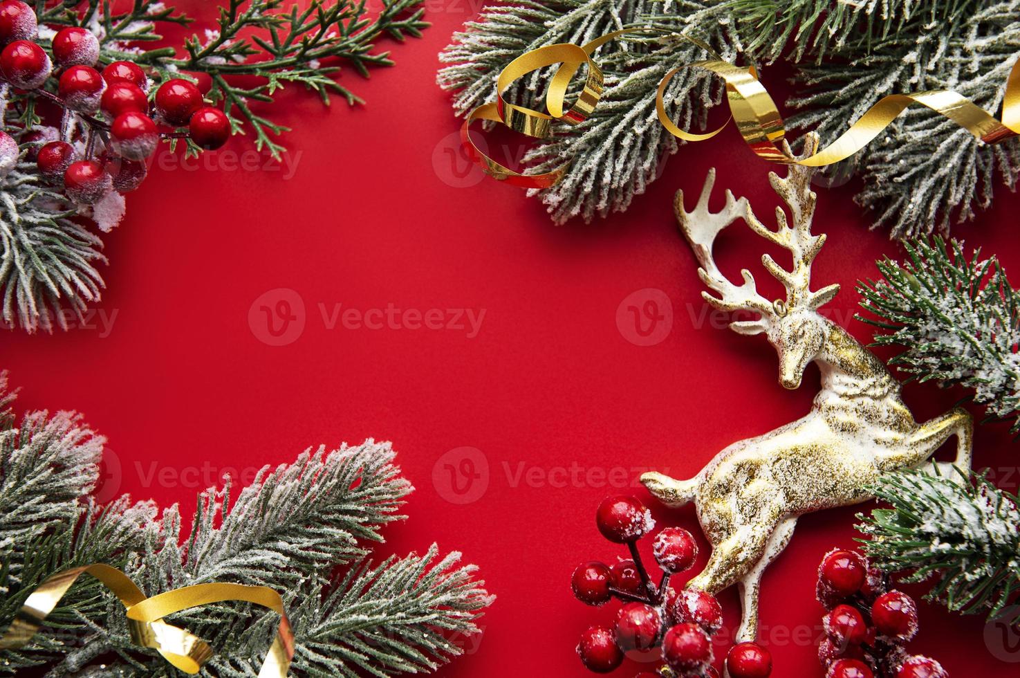 adornos navideños rojos, ramas de abeto sobre fondo rojo foto