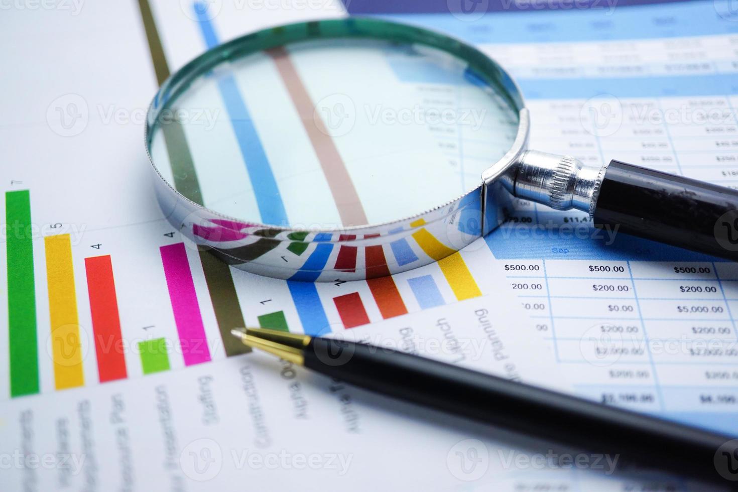 Magnifying glass on charts graphs paper. Financial development, Banking Account, Statistics, Investment Analytic research data economy, Stock exchange trading, Business office company meeting concept. photo