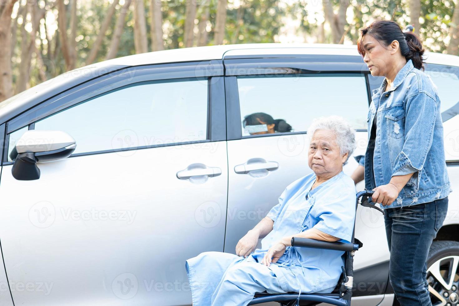 Ayudar y apoyar a la paciente asiática mayor o anciana sentada en una silla de ruedas prepararse para llegar a su automóvil, concepto médico fuerte y saludable. foto