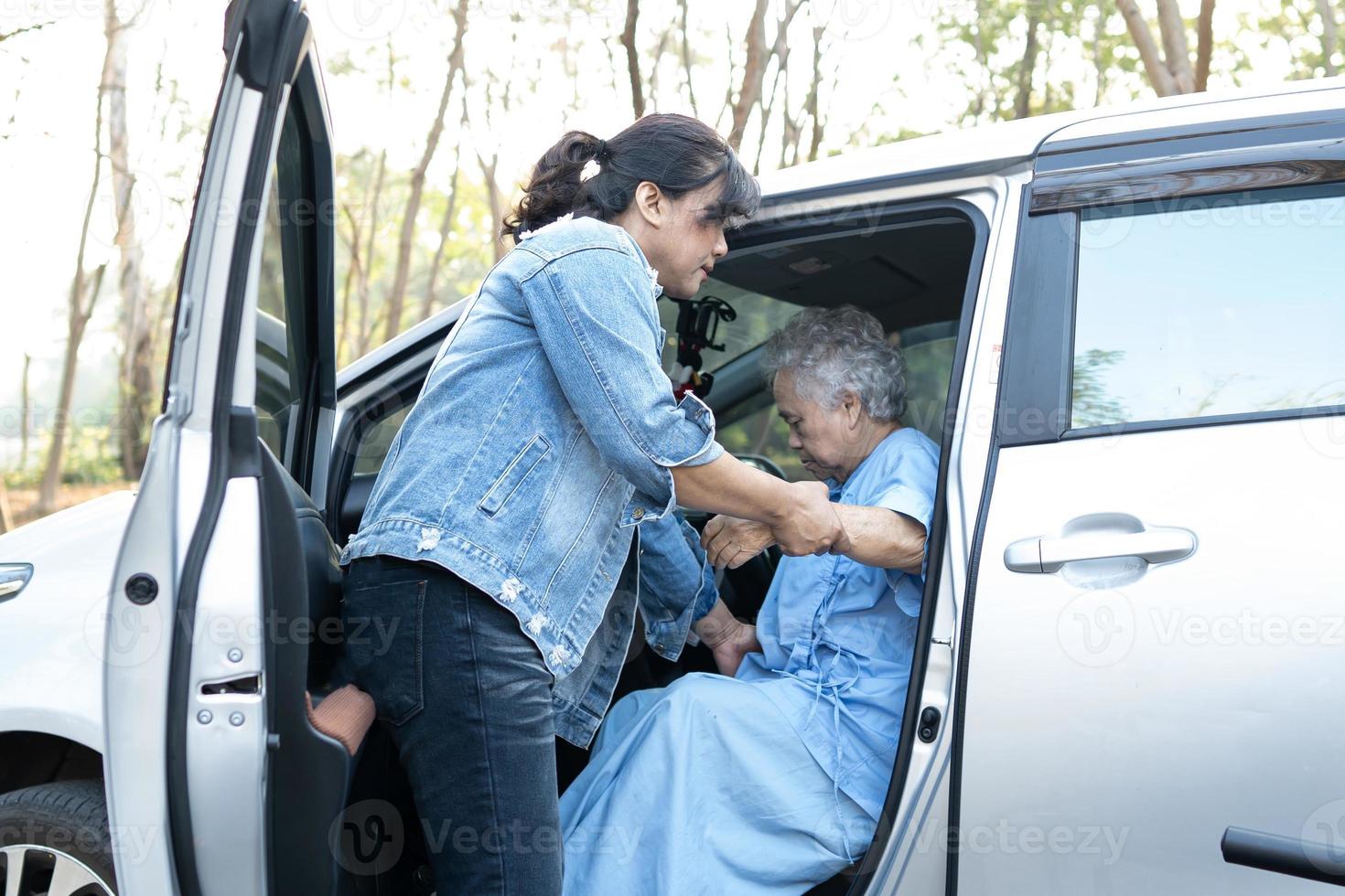 Help and support asian senior or elderly old lady woman patient get to her car, healthy strong medical concept. photo