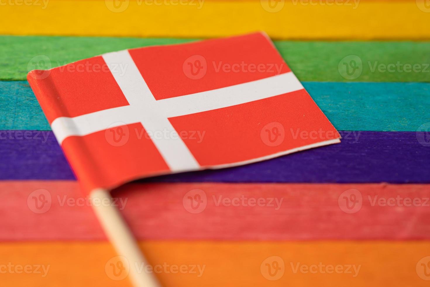 Denmark flag on rainbow background flag symbol of LGBT gay pride month  social movement rainbow flag is a symbol of lesbian, gay, bisexual, transgender, human rights, tolerance and peace. photo