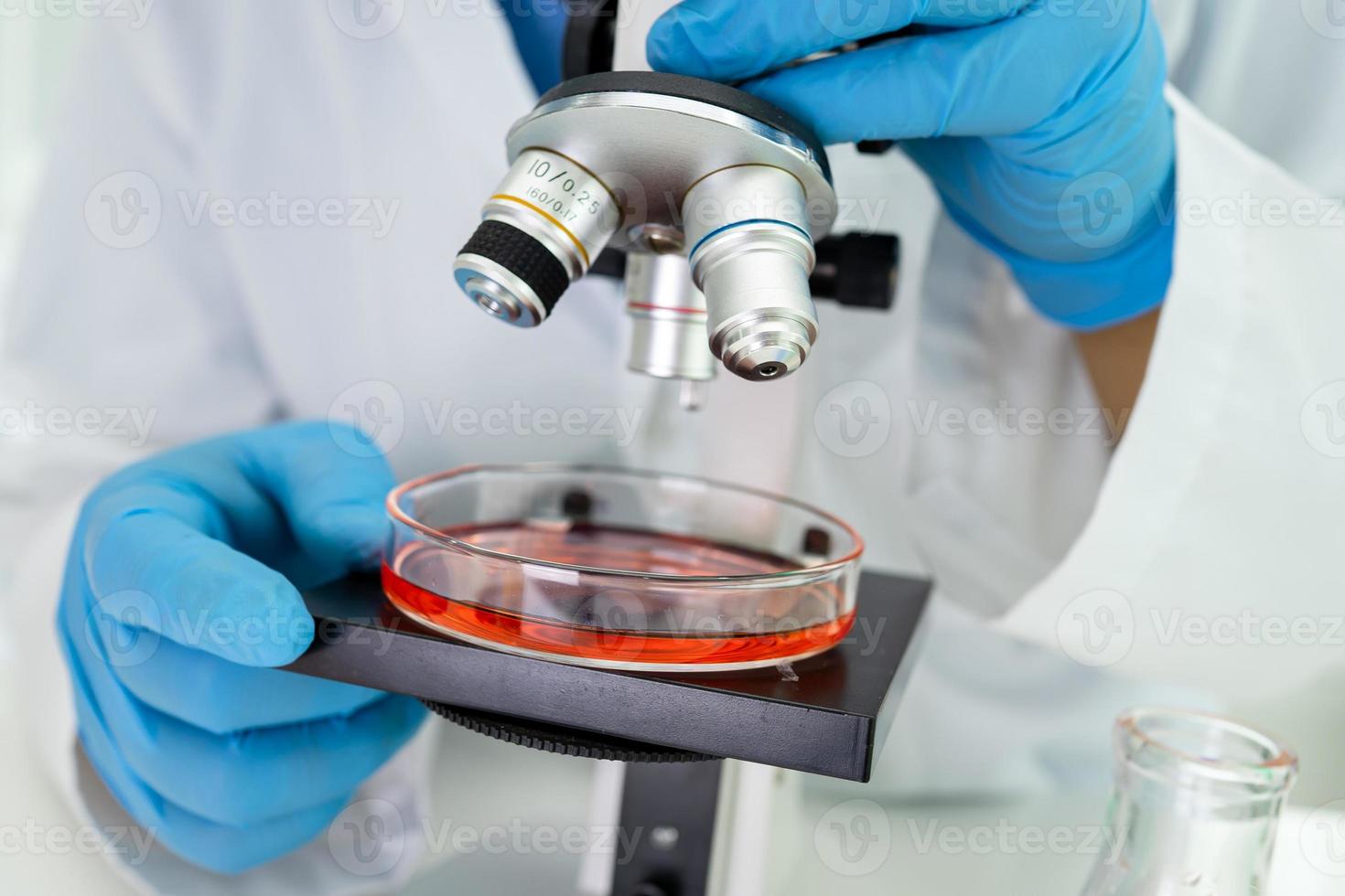 Asian scientist biochemist or microbiologist working research with a microscope in laboratory. For protect outbreak Coronavirus Covid19, bacteria and germs. photo
