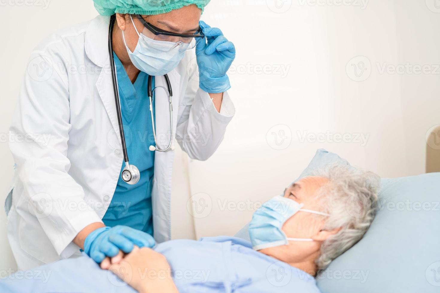 El médico ayuda a la paciente asiática mayor o anciana que usa una mascarilla en el hospital para proteger la infección de seguridad y matar el coronavirus covid-19. foto