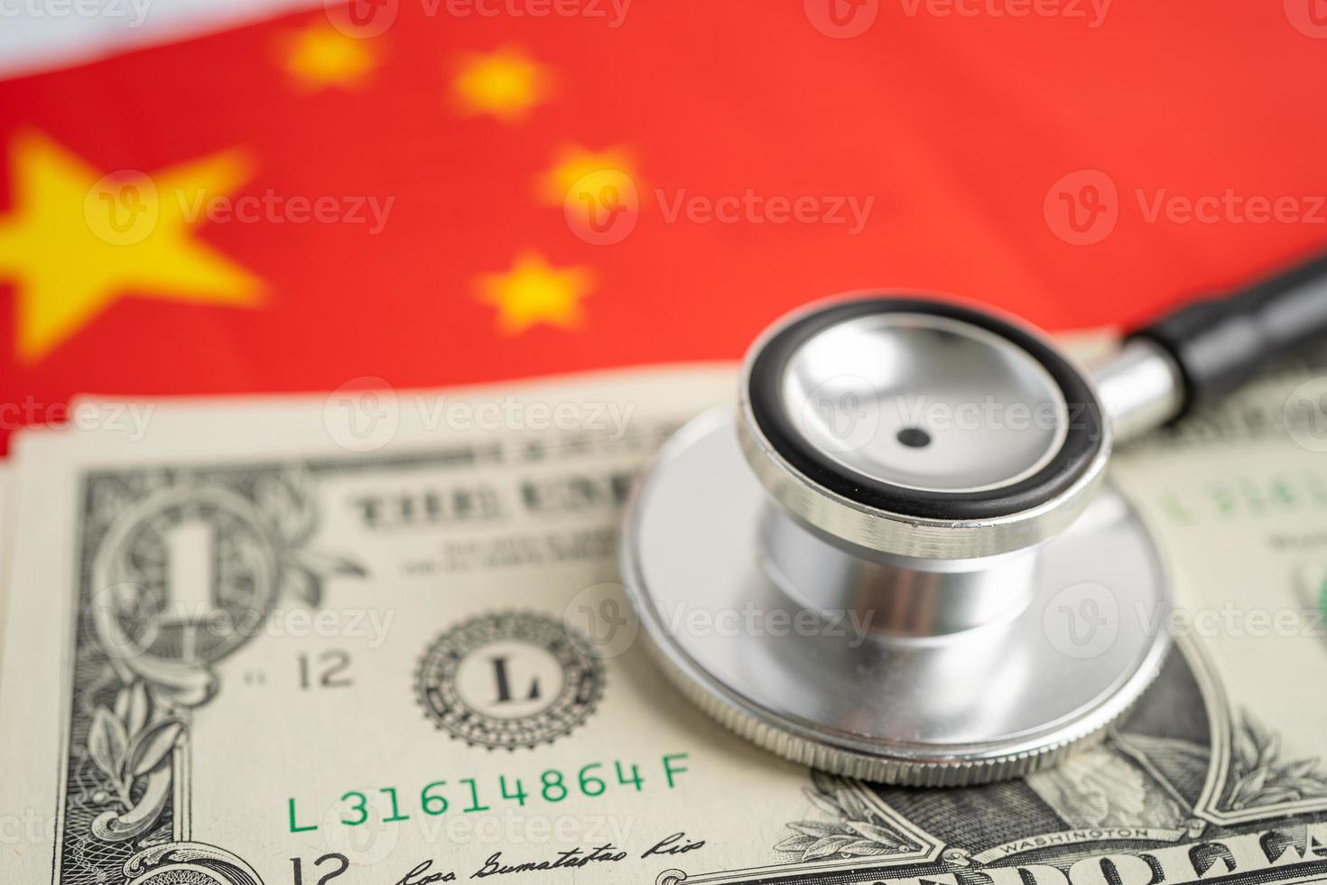 Estetoscopio negro sobre fondo de bandera de China con billetes de dólar estadounidense, concepto de negocios y finanzas. foto