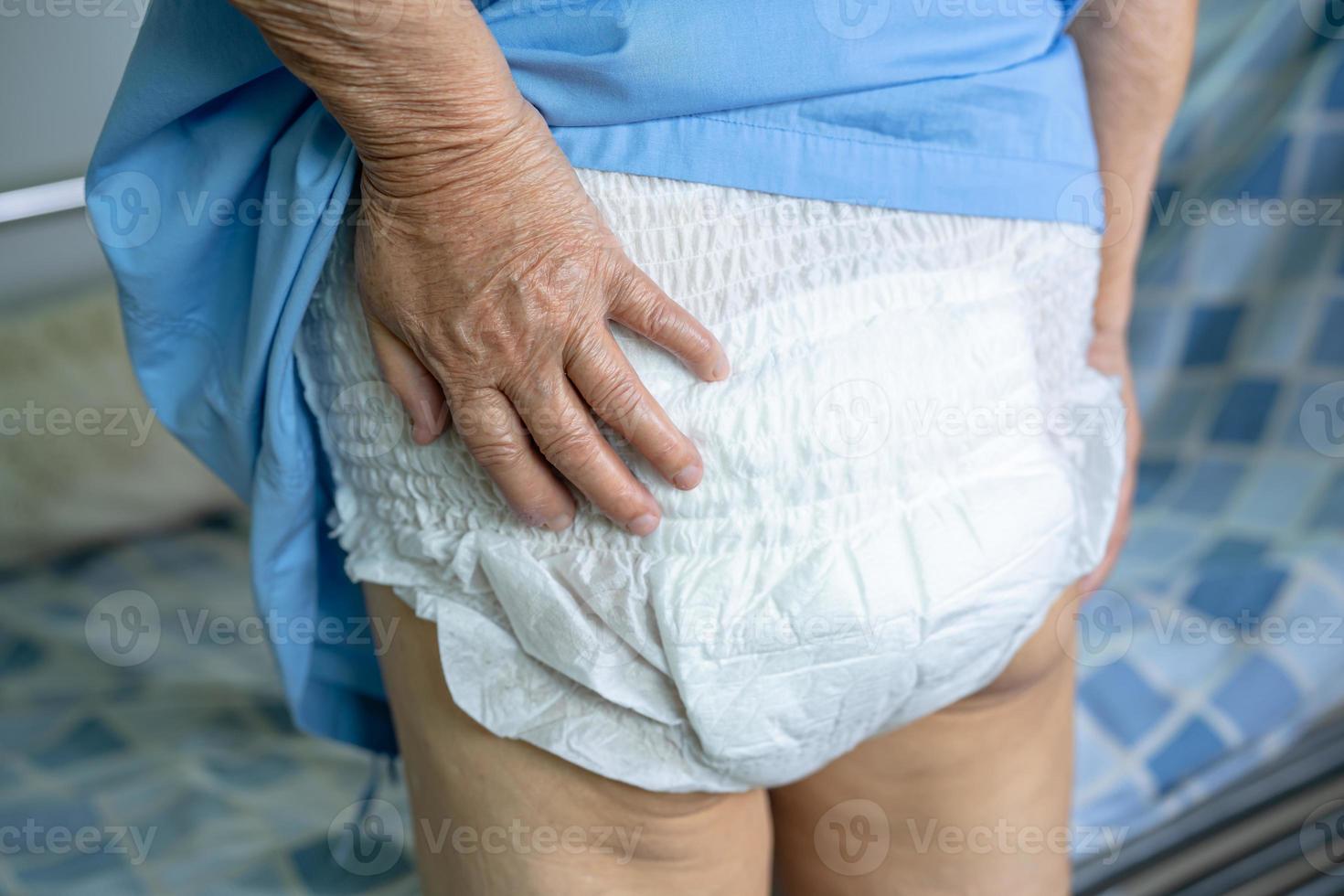 Paciente asiático mayor o mayor de la mujer de la señora mayor que lleva el pañal de la incontinencia en la sala del hospital de enfermería, concepto médico fuerte sano. foto