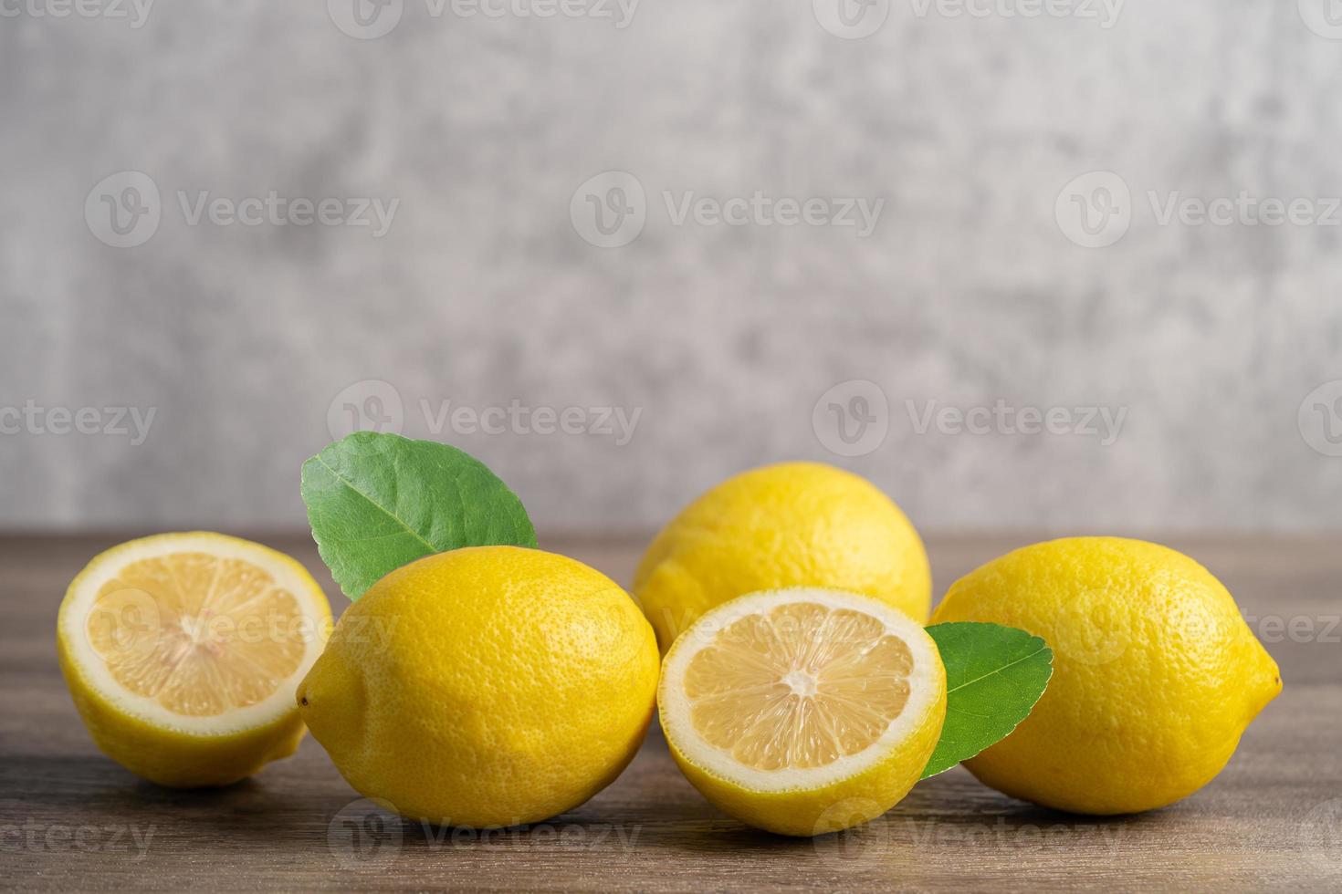 Lemon ripe fresh fruit with leaf on wooden background with copy space photo