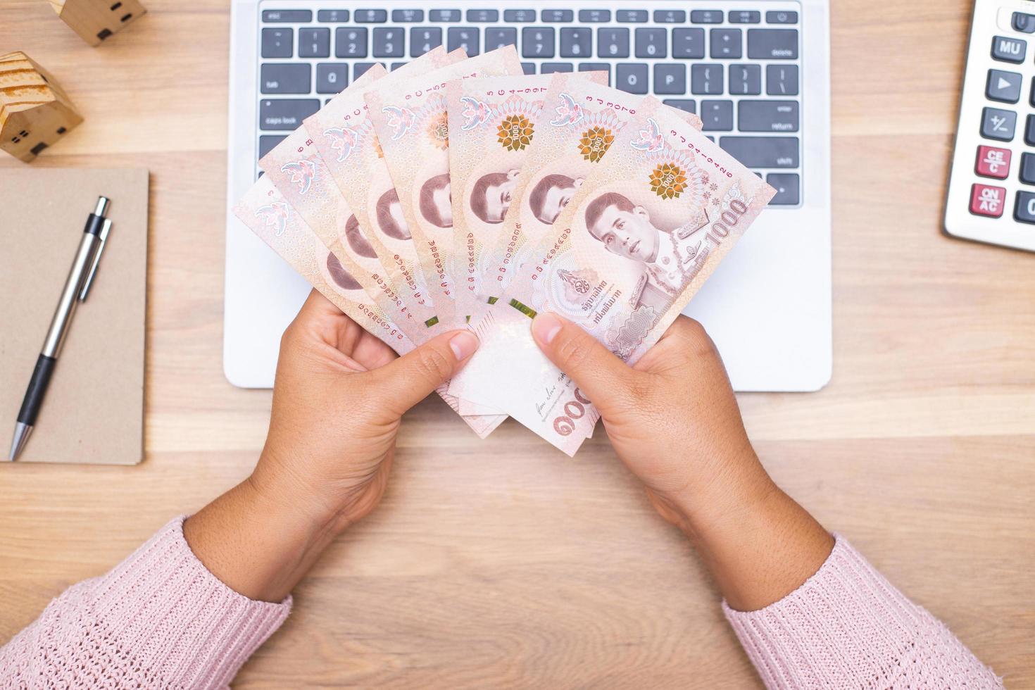 Close up of asian woman with calculator counting money.Woman calculate the spending at home. photo