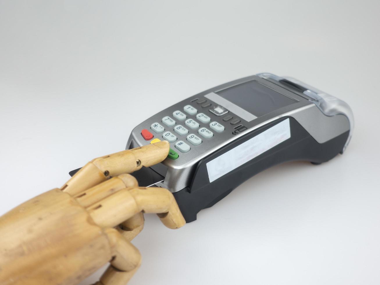 Wooden hand over EDC machine or credit card terminal to made online payment. photo