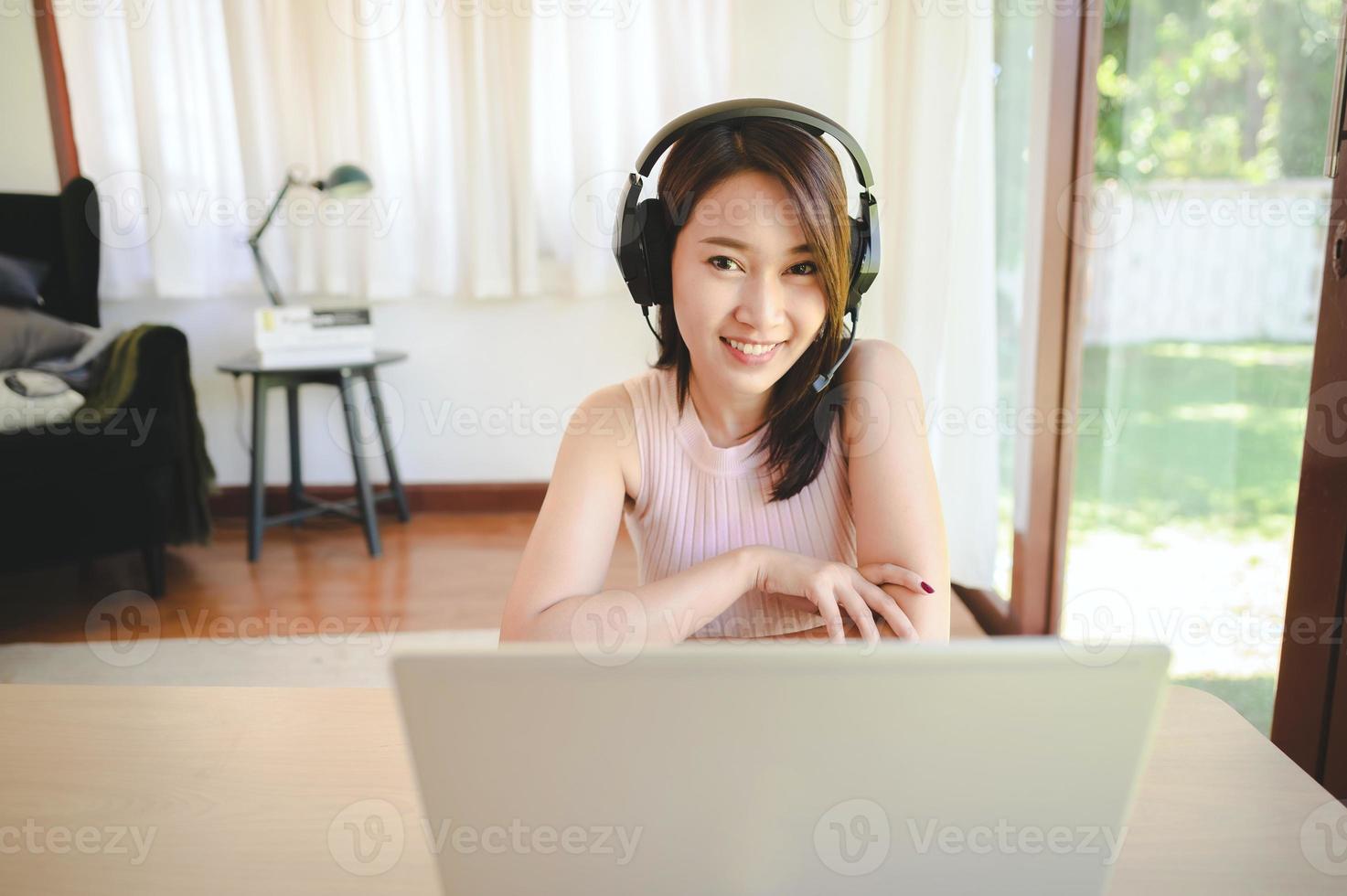 mujer feliz, llevando, auriculares, teniendo, videoconferencia foto