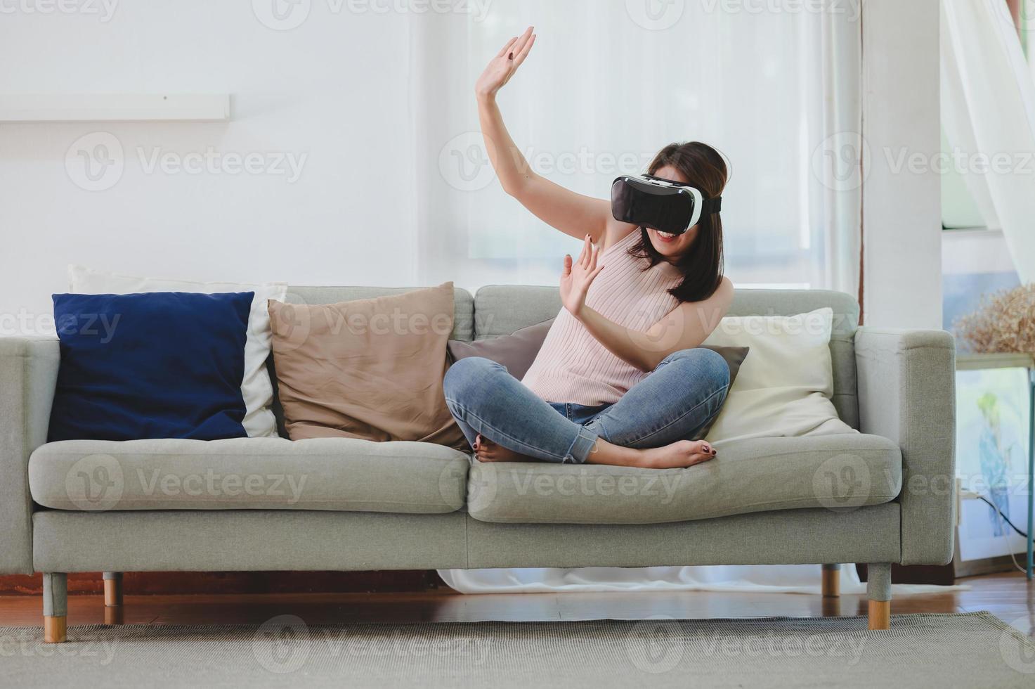 excited Asian woman in VR headset raising both hands up photo