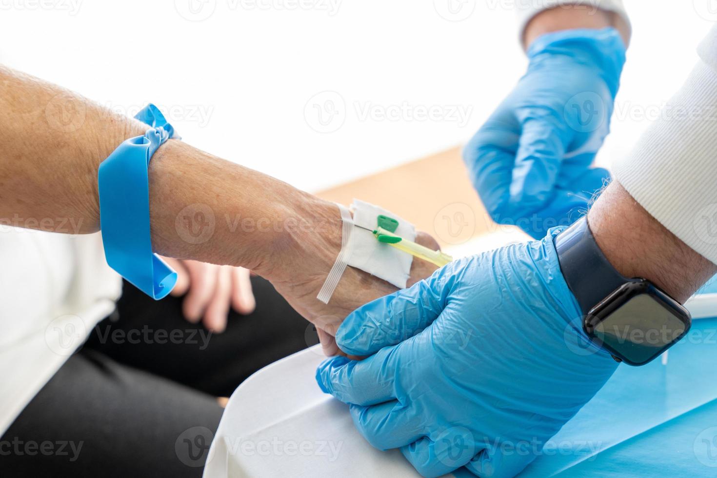 Crop doctor taking blood from elderly patient photo