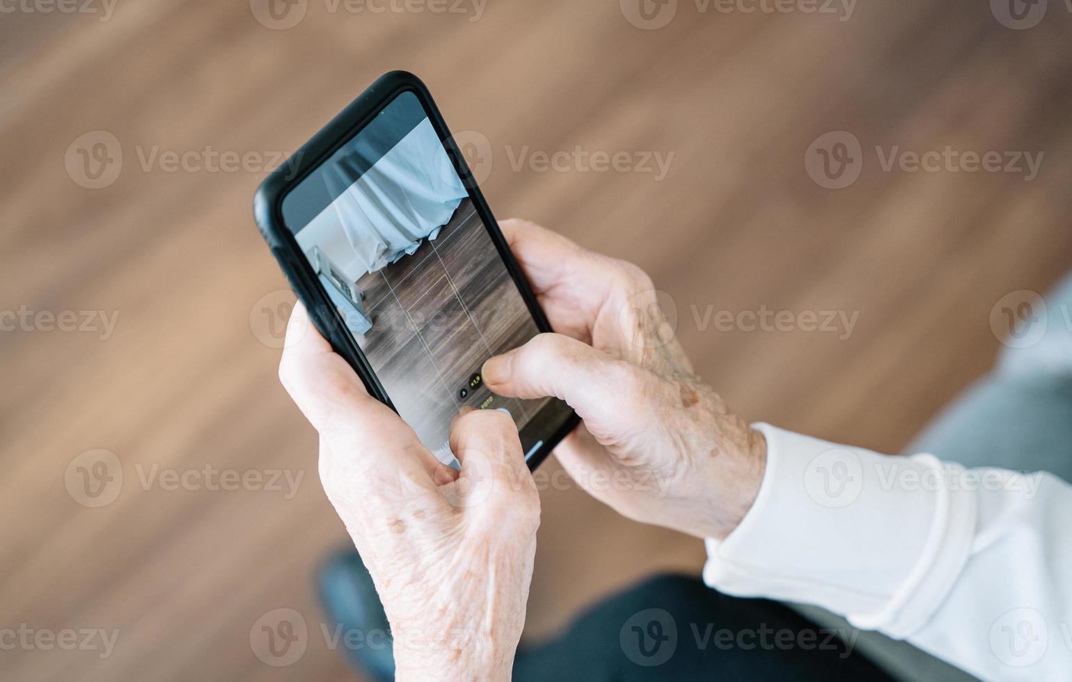 Elderly woman using smartphone at home photo