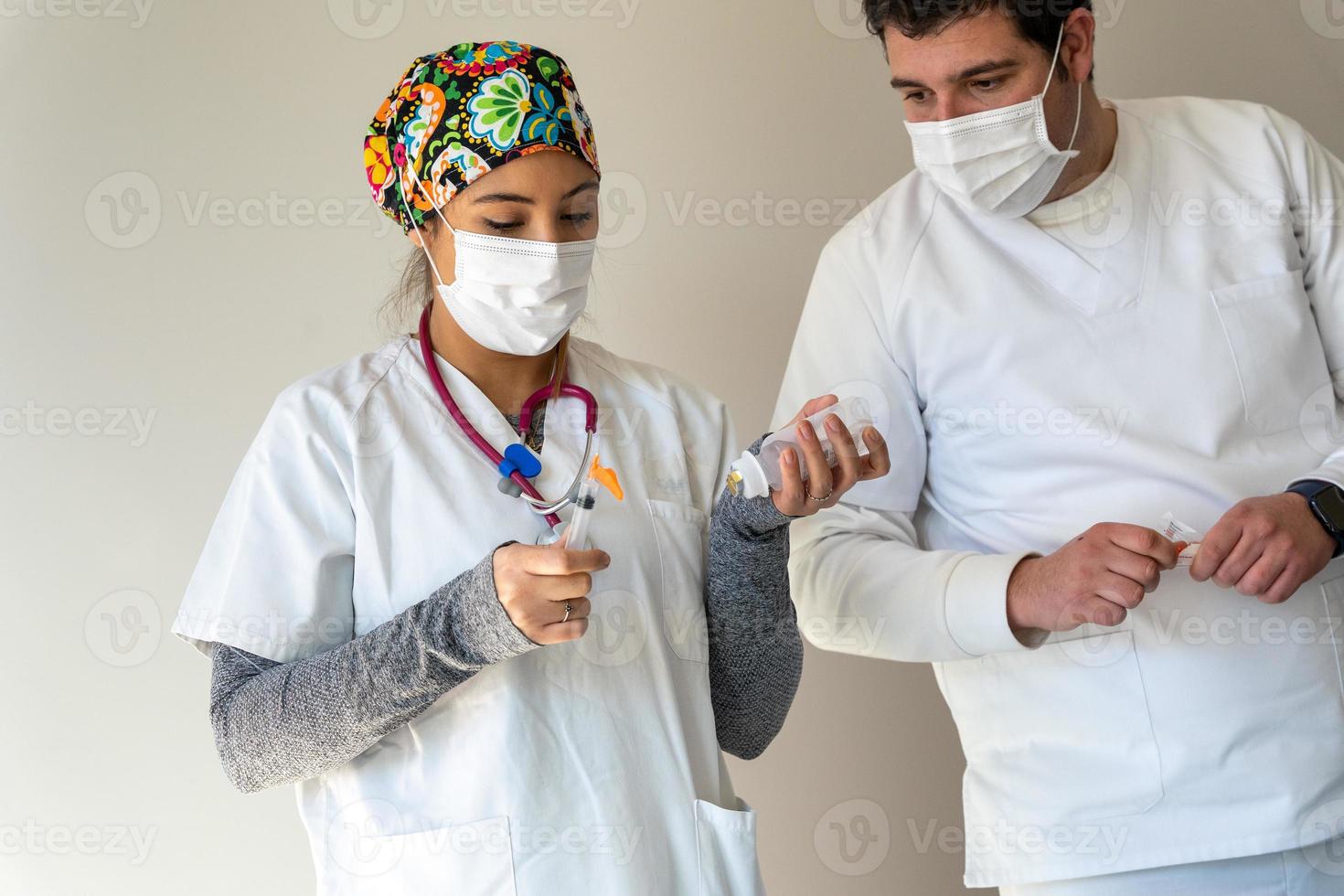 Smiling doctor with syringe in medical room photo