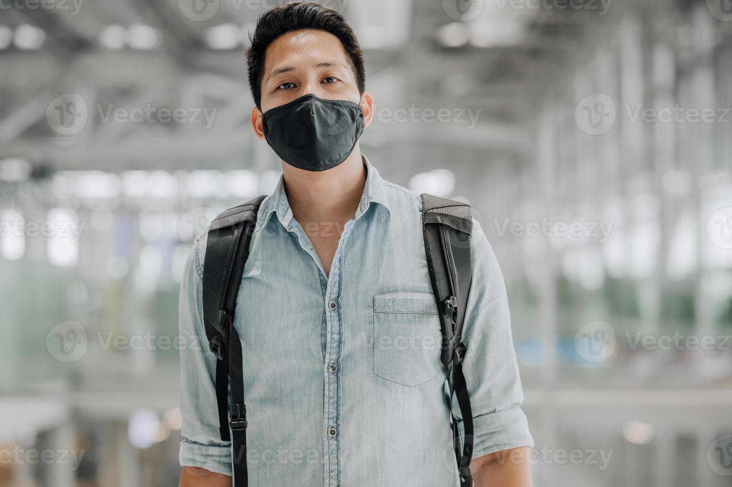 Hombre asiático con mascarilla mirando a la cámara foto