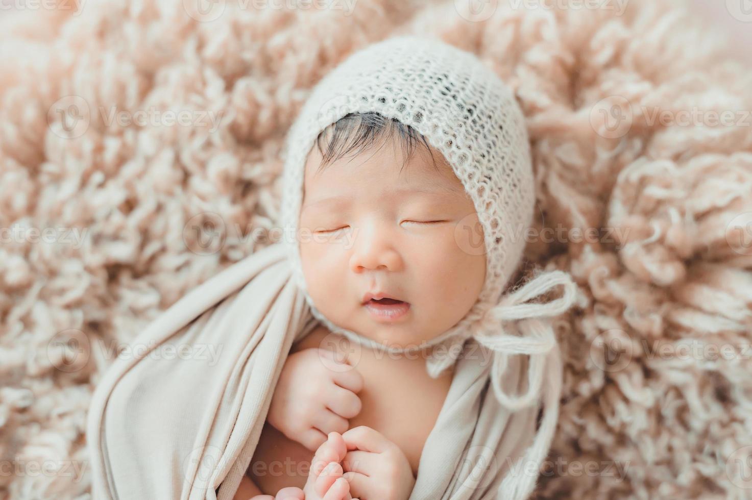 Asian newborn baby with knitted hat sleeping photo