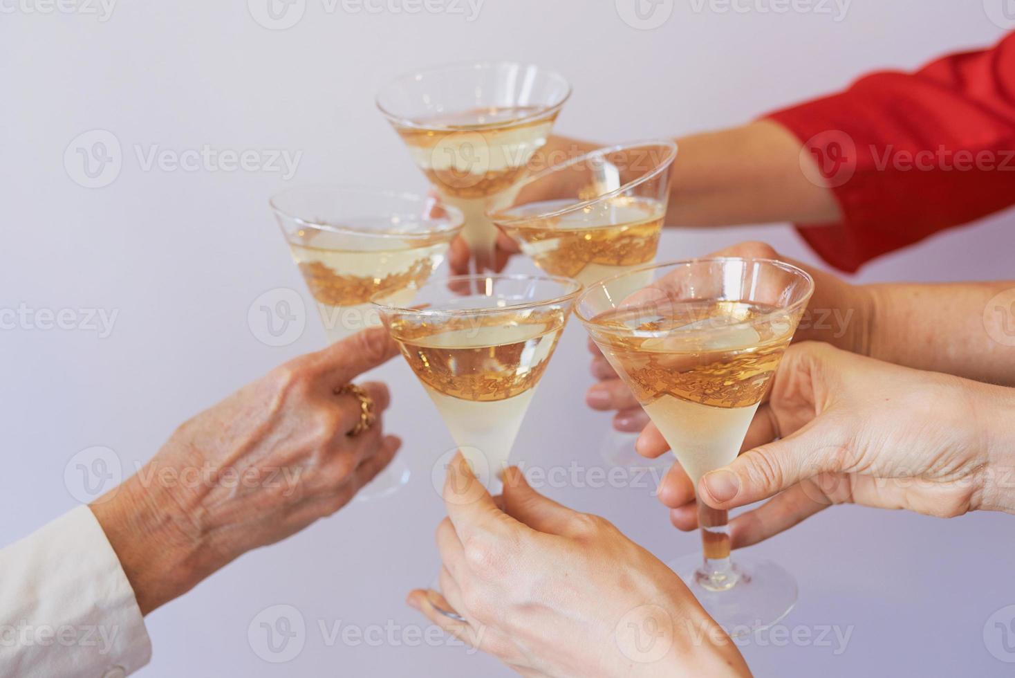 año nuevo celebrando las manos con copas de vino espumoso blanco. navidad, familia, amigos, celebrando, concepto de año nuevo foto