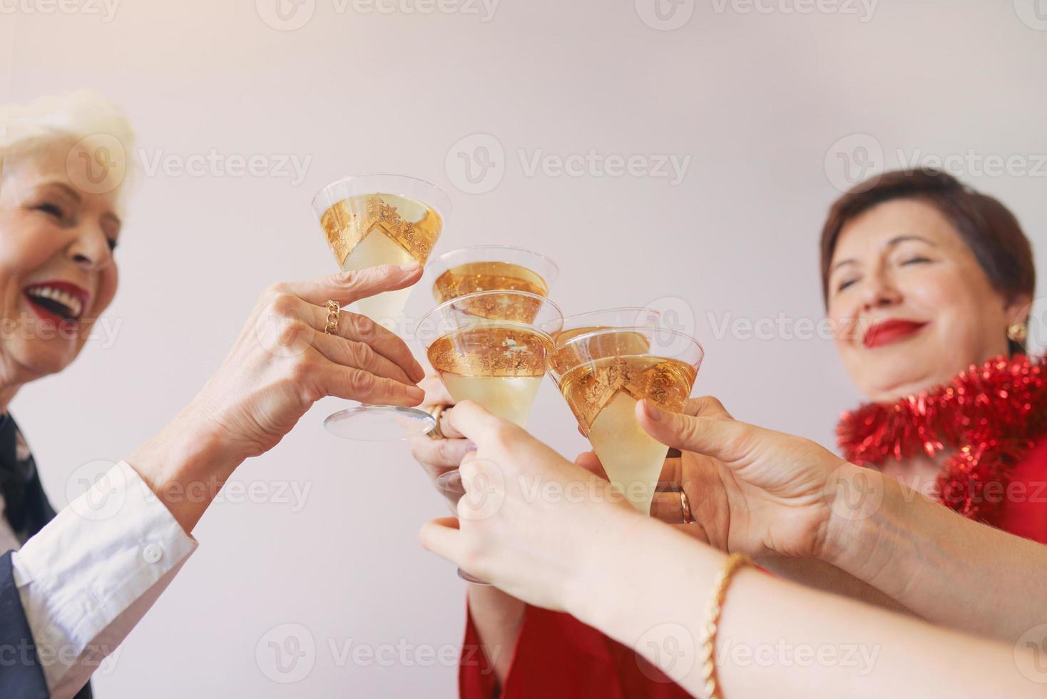 año nuevo celebrando las manos con copas de vino espumoso blanco. navidad, familia, amigos, celebrando, concepto de año nuevo foto