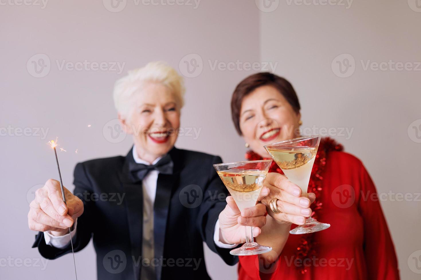 dos hermosas mujeres mayores maduras con estilo celebrando el año nuevo. diversión, fiesta, estilo, concepto de celebración foto