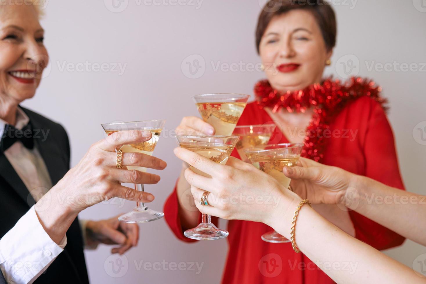 año nuevo celebrando las manos con copas de vino espumoso blanco. navidad, familia, amigos, celebrando, concepto de año nuevo foto