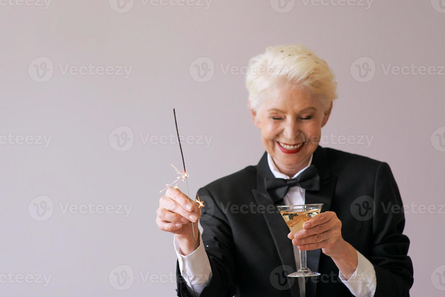 stylish mature senior woman in tuxedo celebrating new year. Fun, party, style, celebration concept photo