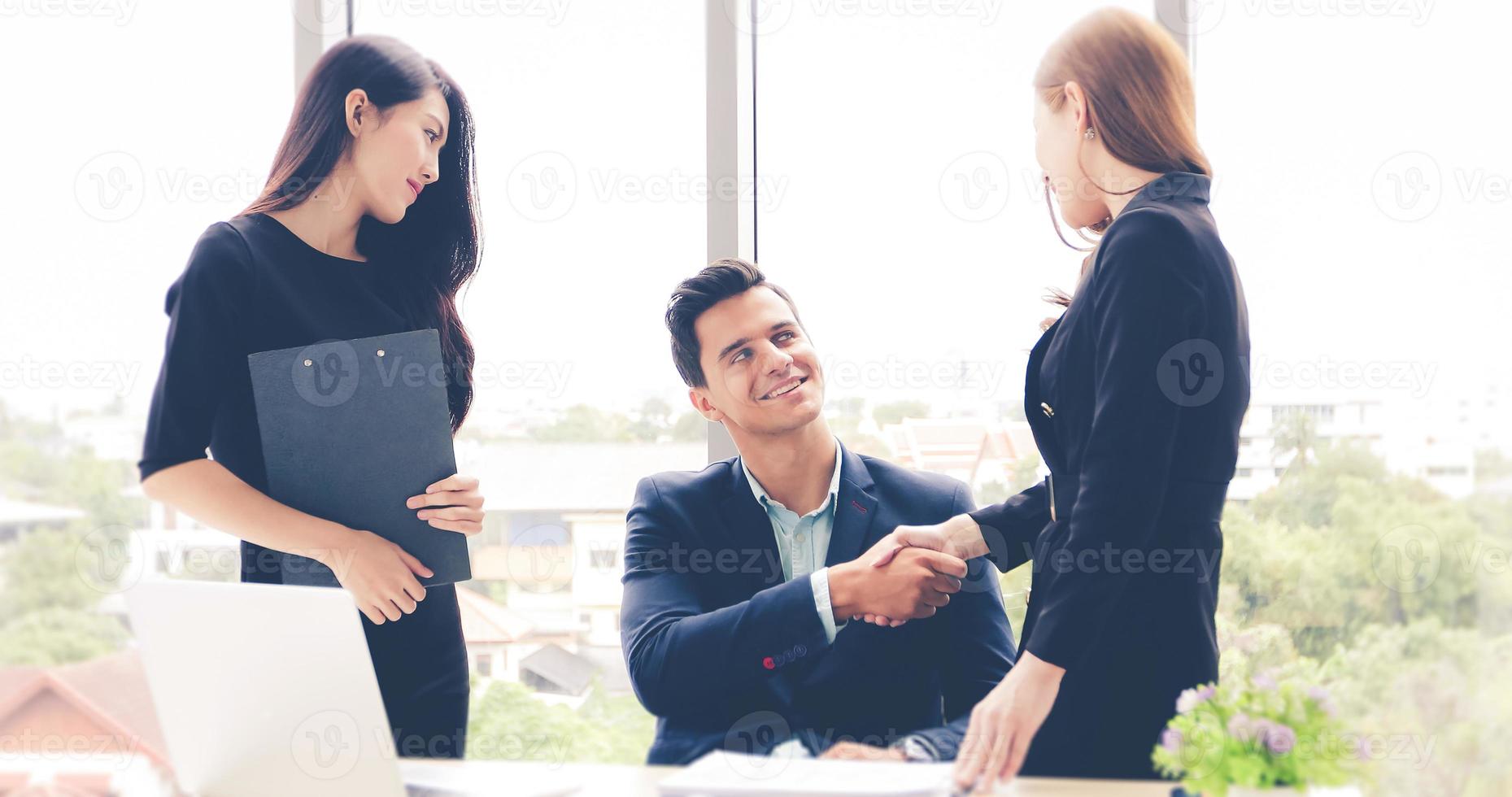 empresarios asiáticos dándose la mano y sonriendo su acuerdo para firmar el contrato y terminar una reunión foto