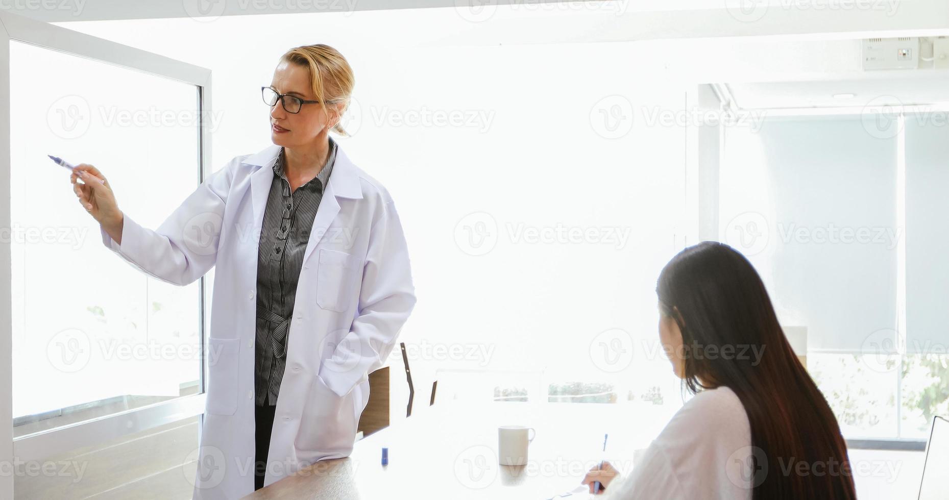 Doctors or scientists are teaching and explaining students and patients writing on board photo