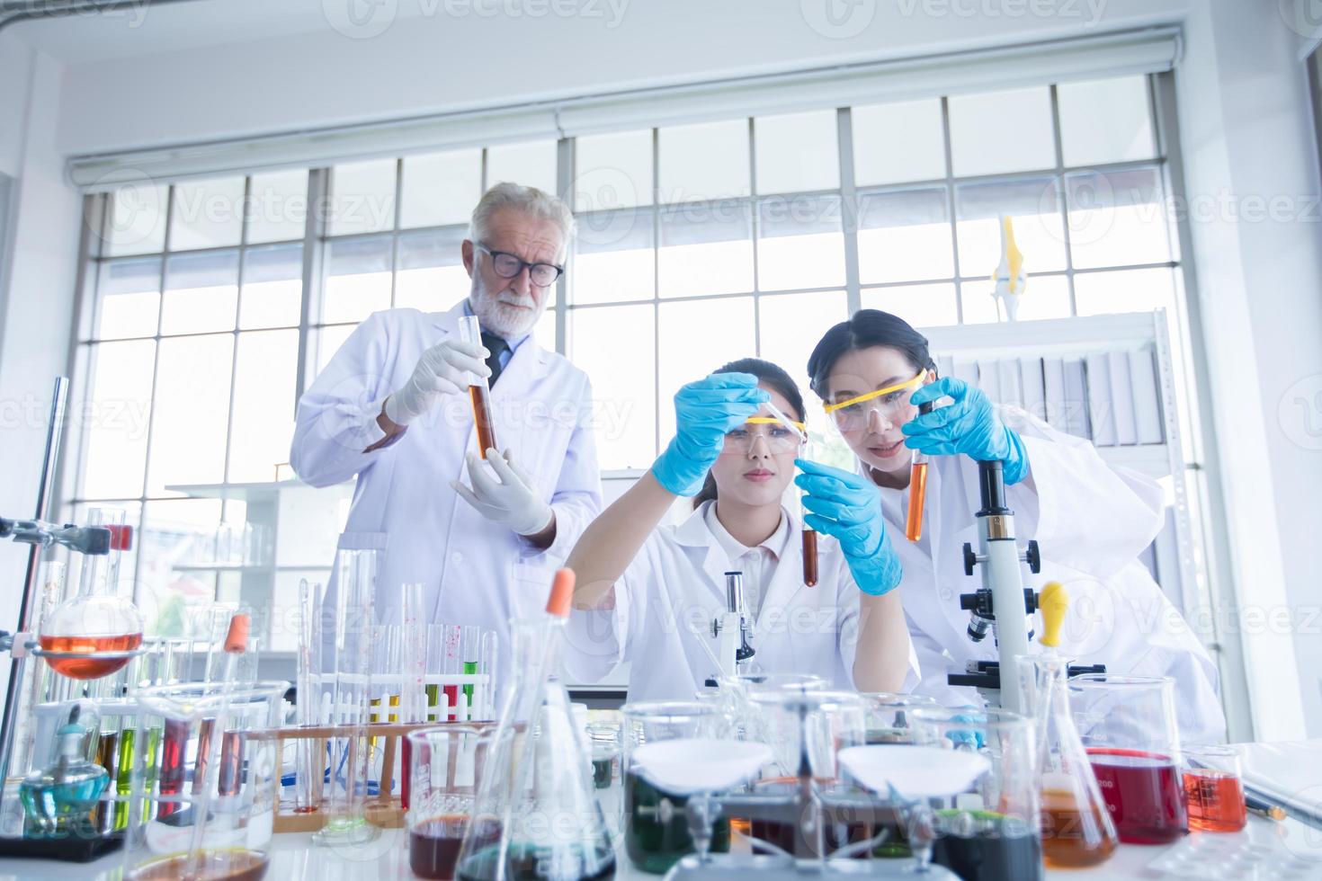 La investigación médica y los científicos están trabajando con un microscopio y una tableta y tubos de ensayo, micropipetas y resultados de análisis en un laboratorio. foto