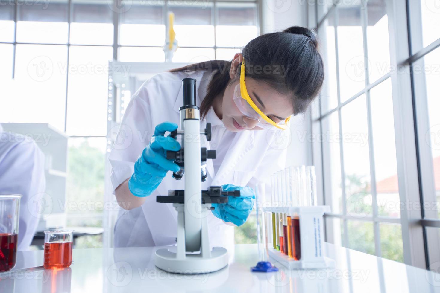 Medical Research and Scientists are working with a microscope and a tablet and Test Tubes, Micropipette and Analysis Results in a laboratory. photo