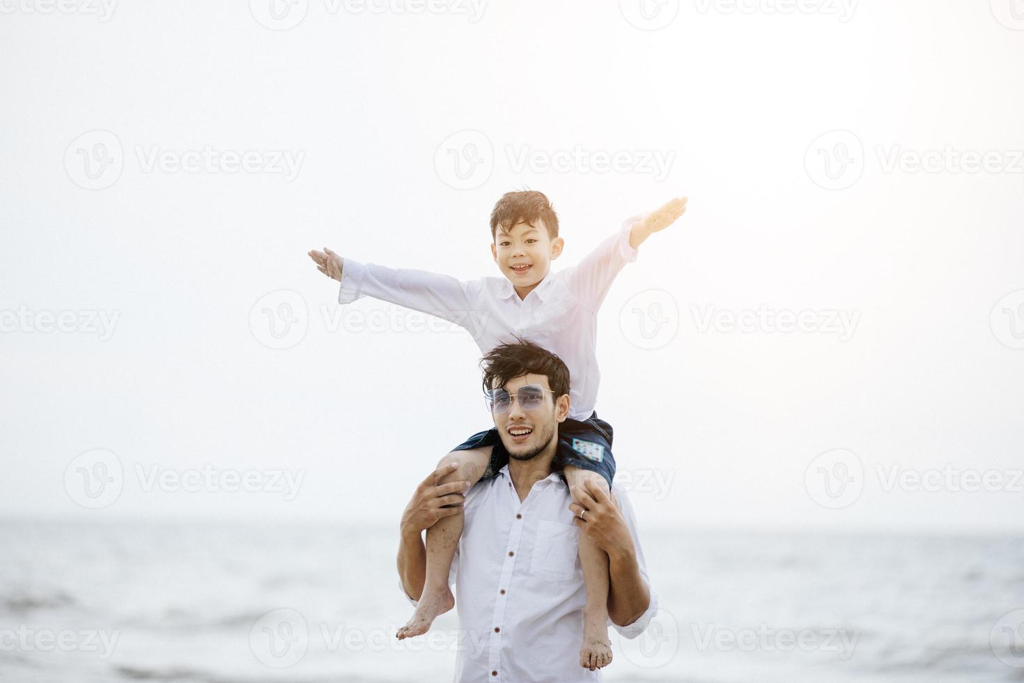 padres activos y personas actividad al aire libre en vacaciones de verano y vacaciones con niños.Familia feliz e hijo caminan con la diversión del mar al atardecer en la playa de arena. foto