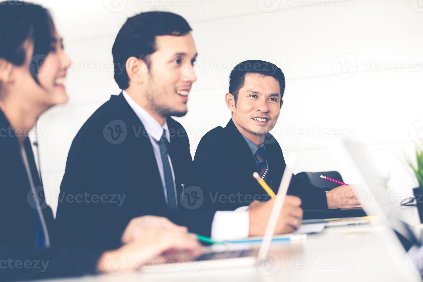 Asian businessmen and group using notebook for business partners discussing documents and ideas at meeting and business women smiling happy for working photo