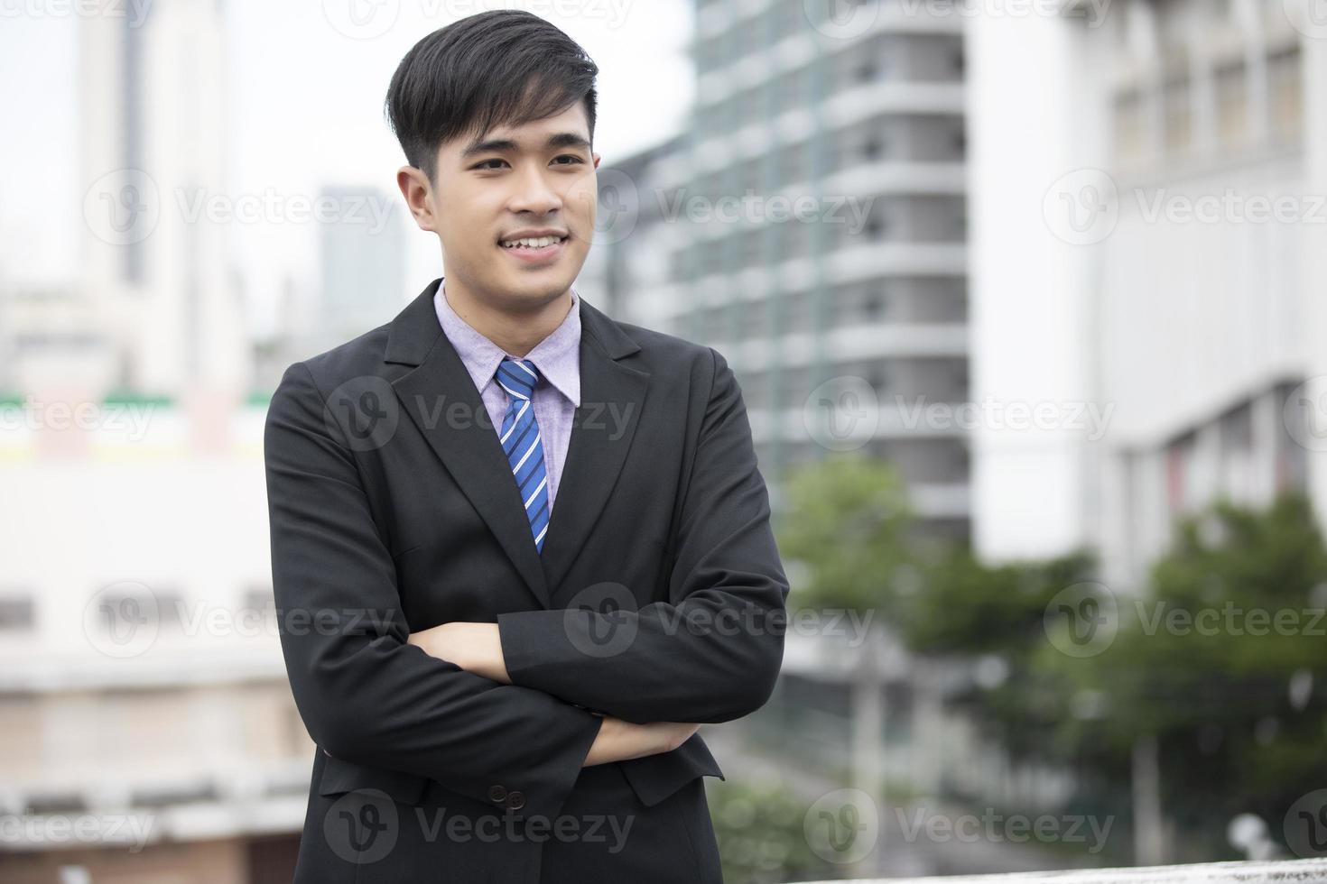 Happy handsome businessman standing and smiling  at outdoor photo