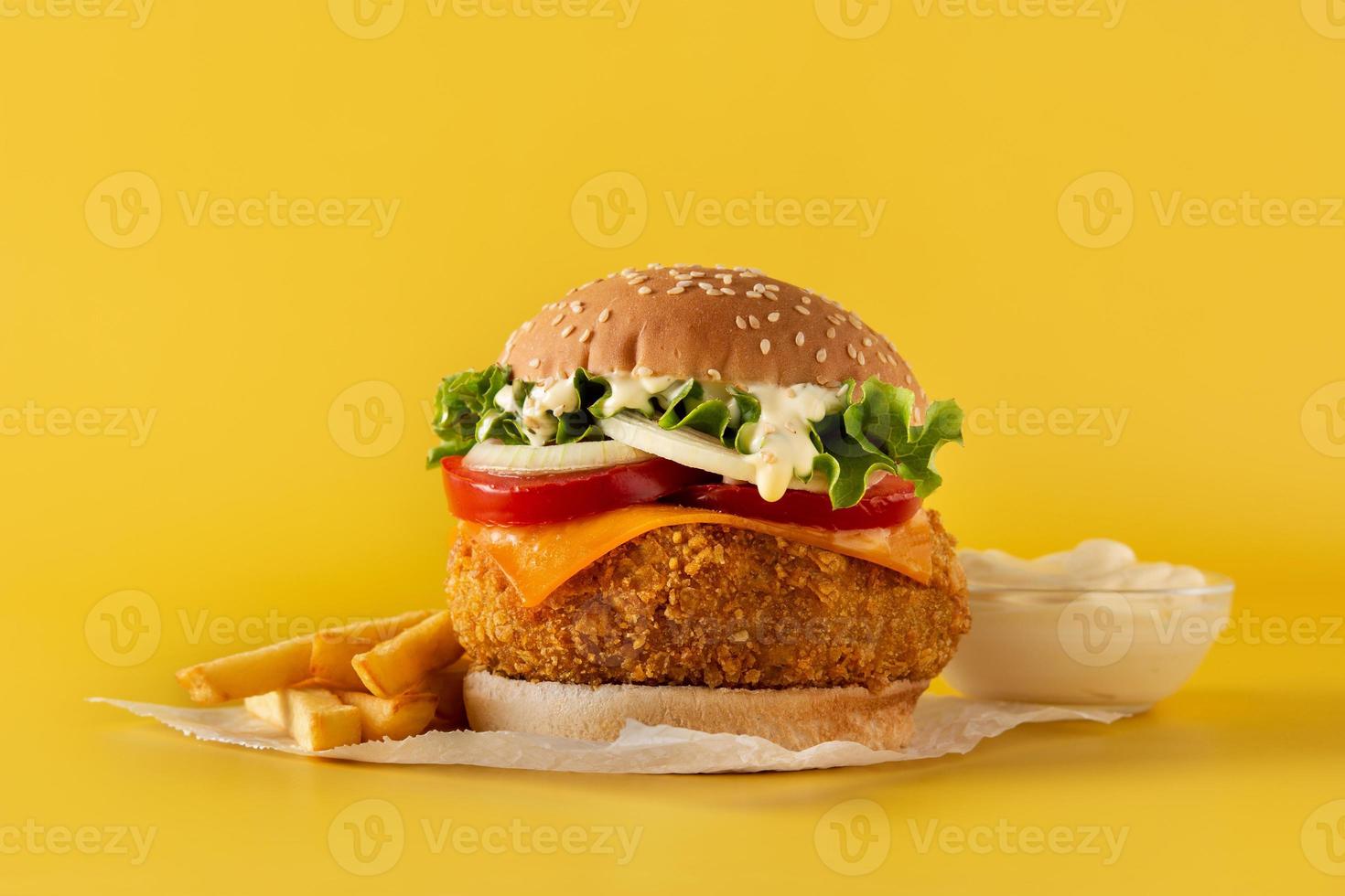 hamburguesa de pollo crujiente con queso y papas fritas foto