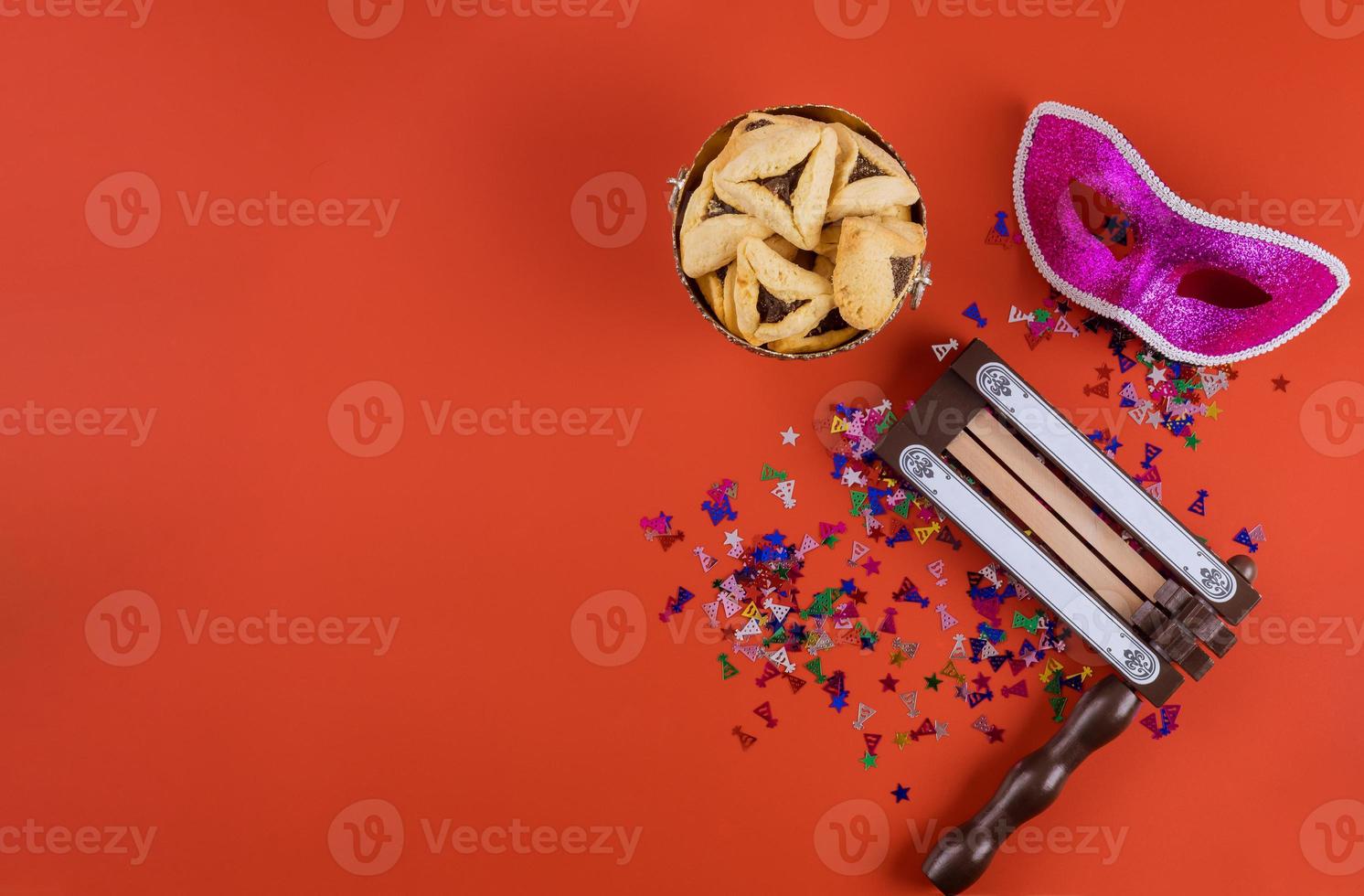 Celebración tradicional de la festividad judía de Purim en el hamantaschen cookies, matraca y carnaval de máscara foto