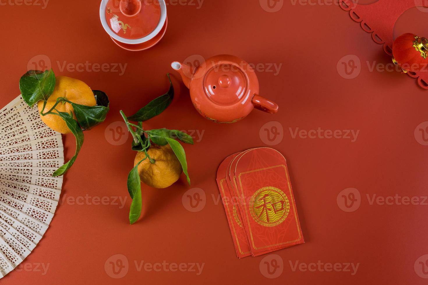 Lunar Chinese New Year celebrations symbol decorations ornament, with Asian tea set money packet Ang Pau on red background photo