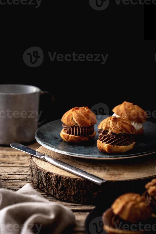 Delicious profiteroles on rustic wooden table photo