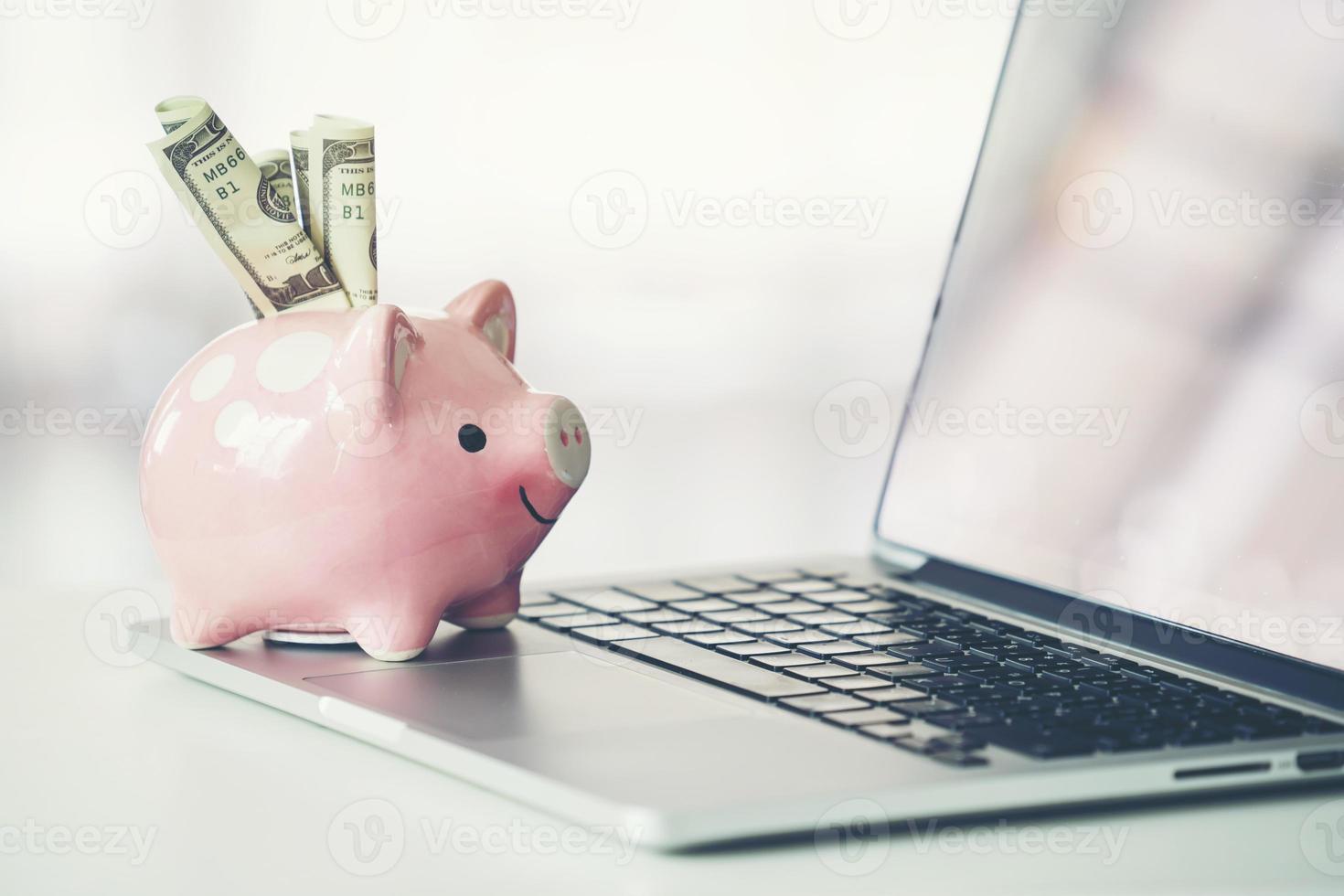 piggy bank with laptop on the desk photo