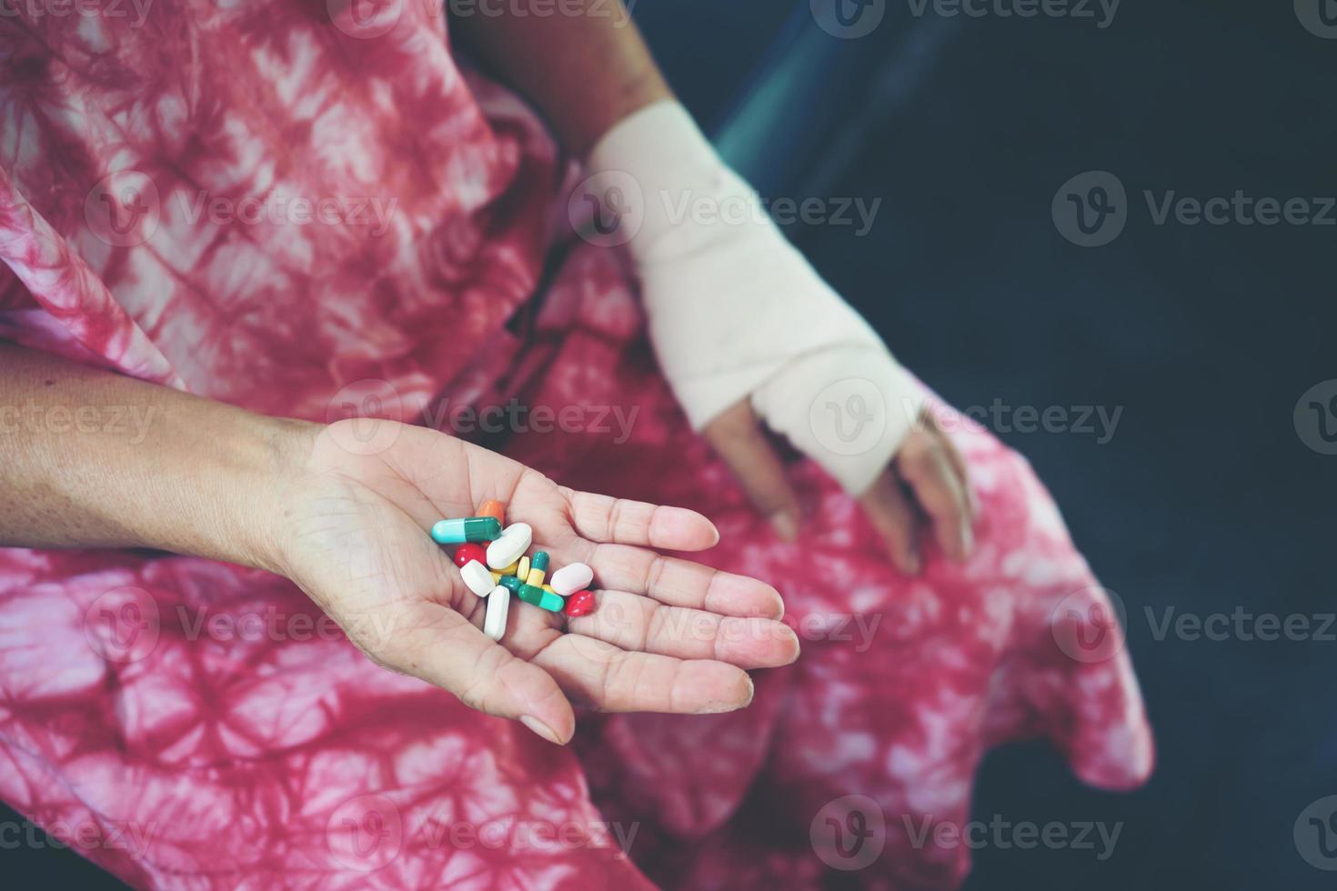 Senior asian woman take pill medicine on hand photo